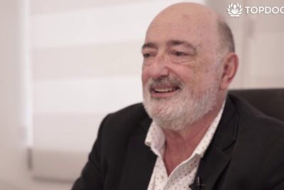 Smiling elderly man seated in an office, conveying a professional moment related to efectos negativos 2.