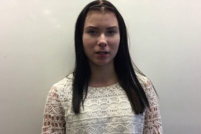 Front-facing portrait of a young woman in a white lace top for ekologiska produkter lifestyle imagery.