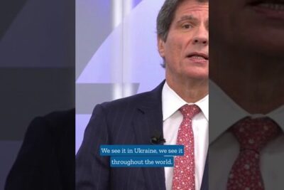 Male news commentator in suit with on-screen caption discussing ekonomiskt samarbete