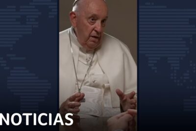 Elderly religious leader in white robes speaking in a televised interview about el aborto 26.