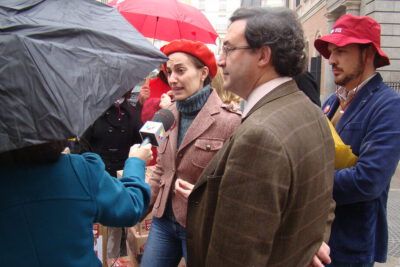 Woman speaking to a TV reporter under umbrellas during a street interview at reproductive rights rally el aborto 5 - media coverage photo.