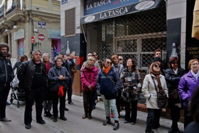 A group of onlookers gathered on a narrow city street, suitable for articles on el burka and public reactions.