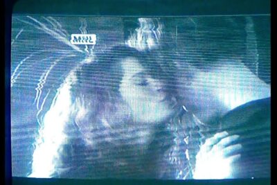 Grainy vintage television close-up of two people kissing with horizontal scanlines and static, el zar 1