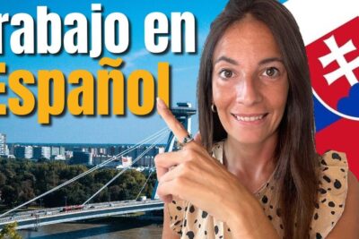 Smiling woman pointing to large 'Trabajo en Español' text with a city skyline, cable-stayed bridge and Slovak flag, highlighting emigrar busca