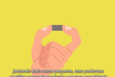 Hand holding a small dark capsule between fingertips on a bright yellow background energia nuclear 19