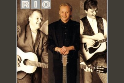 Three smiling men with acoustic guitars in a sepia vertical triptych portrait featuring eron jalkeen.