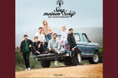 Casual group of adults gathered on the tailgate of a blue pickup truck in a rural setting, es wichtig 11