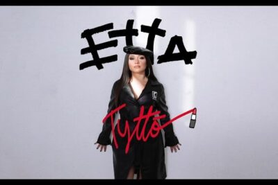Portrait of a person in black coat and hat on a minimalist album cover featuring the text etta elama 4 and red handwritten script
