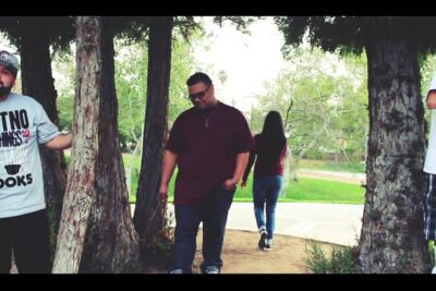 Three men leaning against trees and a person walking away on a park path f sse 1.