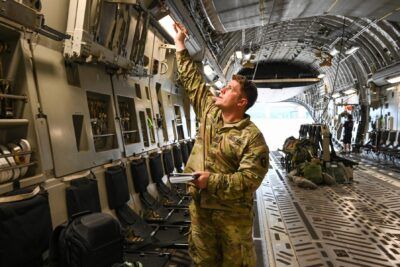 U.S. Army soldier performing an interior cargo bay inspection inside a transport aircraft for att 90.