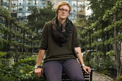 Person sitting on a bench in an urban garden, contemplative portrait for eutanasi