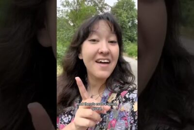 Young woman outdoors pointing to camera in a floral blouse for jamlikhet
