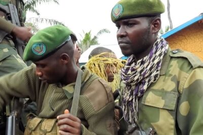 Uniformed soldiers wearing green berets and camouflage clustered in a transport vehicle relating to fredsprocessen ar