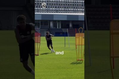 Athlete running through training mannequins and poles on a green soccer field as part of fysisk traning 1