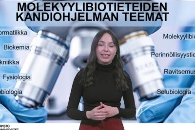 Presenter stands before a molecular biosciences poster with microscope imagery and program topics, featuring the phrase geenimuunneltujen organismien 3