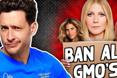 Skeptical medical professional in blue scrubs beside protesters holding a cardboard sign reading 'BAN ALL GMO'S', genetically modified 13