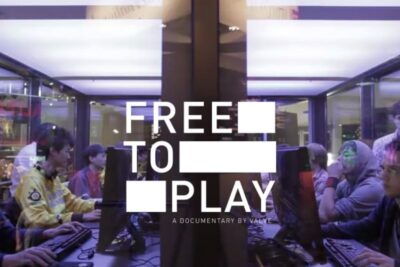 Young gamers seated at PCs in a LAN setting under a bold 'FREE TO PLAY' overlay, genetisk utvelgelse 1.