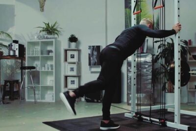 Person performing a single-leg cable kickback in a home gym that ger mojlighet for lower-body strength and balance.