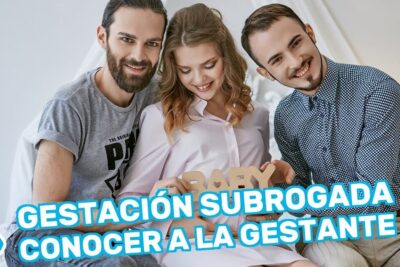 Smiling pregnant woman seated between two adults holding baby letters during a gestacao subrogada meeting.