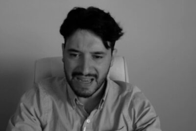 Black-and-white portrait of a distressed man in a collared shirt, evocative imagery for giustificazione condanna content.