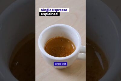 Single espresso shot in a white cup on a light wooden surface with visible crema, gmo ruoat voivat