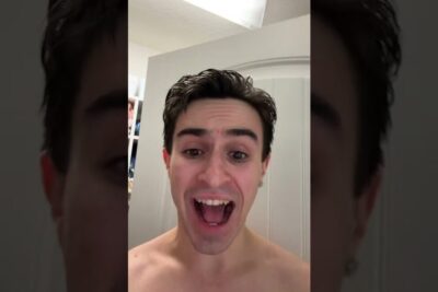 Close-up vertical selfie of an excited shirtless young man in a bathroom, homofil adopsjon 1
