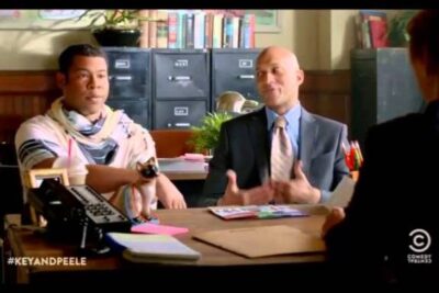 Two men seated across an office desk during a consultation, suggesting a homoseksuel adoption 3 scenario.