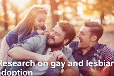 Two men laughing and playing with a young girl outdoors in warm sunlight, homoseksuel adoption 6