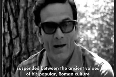 Black-and-white portrait of a man wearing dark sunglasses with a subtitle about Roman culture, il consumismo 1