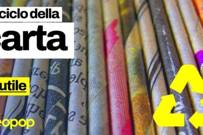 Close-up of rolled printed paper tubes and a bright yellow recycling symbol illustrating il riciclaggio of paper.