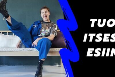 Smiling person in a blue jumpsuit kicking a leg up on a bench, a vibrant scene that invites ilmaista itseaan