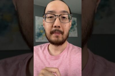 Close-up portrait of an adult male-presenting person wearing glasses and a pink shirt for imod bioetik visual use.