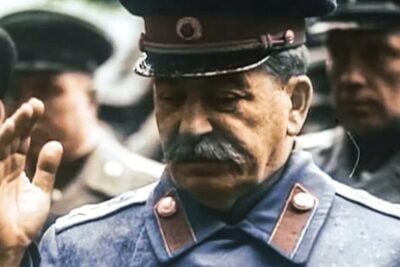 Older uniformed officer with moustache raising his hand in a solemn military scene imod dommen