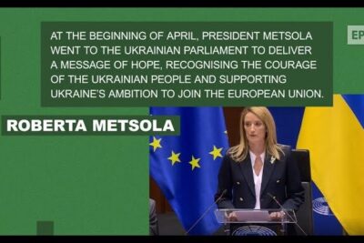 Speaker at a podium with European Union and Ukrainian flags emphasizing Ukraine's ambition to join the EU and imod eu medlemskab