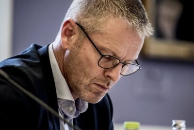 Man in glasses concentrating at a meeting about imod omskaring