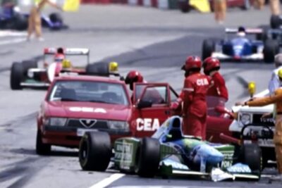 Track marshals and safety vehicles attending to a stopped open-wheel race car during a track incident imod skabne.