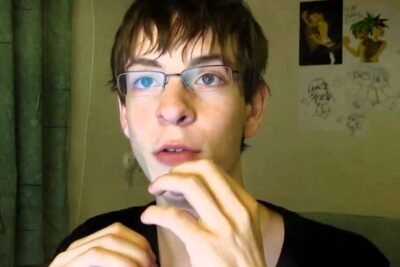 Person wearing glasses with hands near face looking thoughtful, suitable for imod spil content.