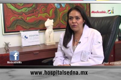 Female physician in white coat in an office setting discussing infancia temprana and pediatric health