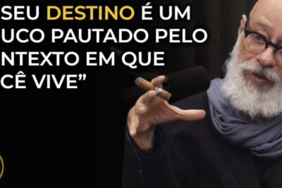 Bearded man gesturing and speaking into a microphone with on-screen text about influencia destino