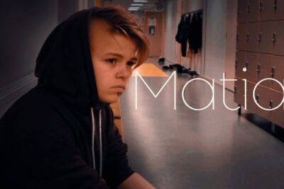 Hooded teenager sitting alone in a school corridor jotkut saattavat 2