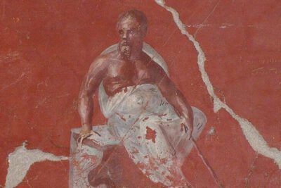 Seated bearded philosopher in a red-toned fresco scene, juicio socrates 1