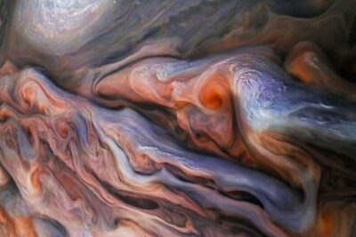 Vivid swirling cloud bands and colorful vortices resembling jupiters ringe