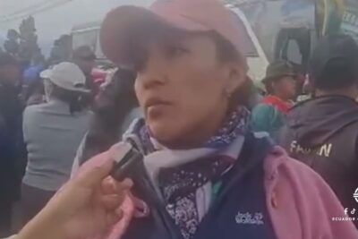 Woman wearing a pink cap and scarf being interviewed in a crowded outdoor gathering justicia indigena 1.