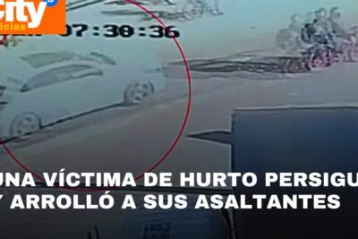 CCTV screenshot of a circled white car in a street pursuit labeled justicia mano