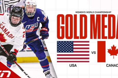 Two women's hockey players in Canada and USA jerseys battling for the puck in a kanada usa gold medal matchup.