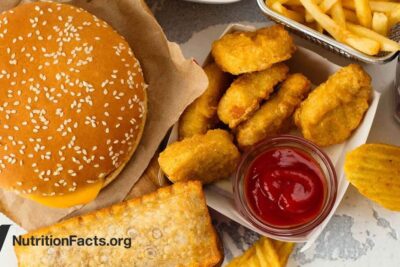 Cheeseburger, chicken nuggets, fries and dipping sauce illustrating konsum junk food
