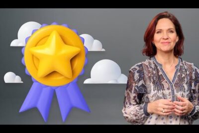 Female presenter standing beside a large star ribbon badge and clouds symbolizing kontinuerlig forbedring 2 and continuous improvement