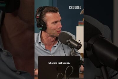 Male podcast host wearing headphones speaking into a studio microphone during kontroverse debatten