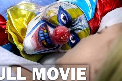 Close-up of a colorful sinister clown mask with a red nose resting on fabric near a person, kraken virkelig 1