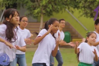 Group of children dancing outdoors in white shirts celebrating la igualdad 2.